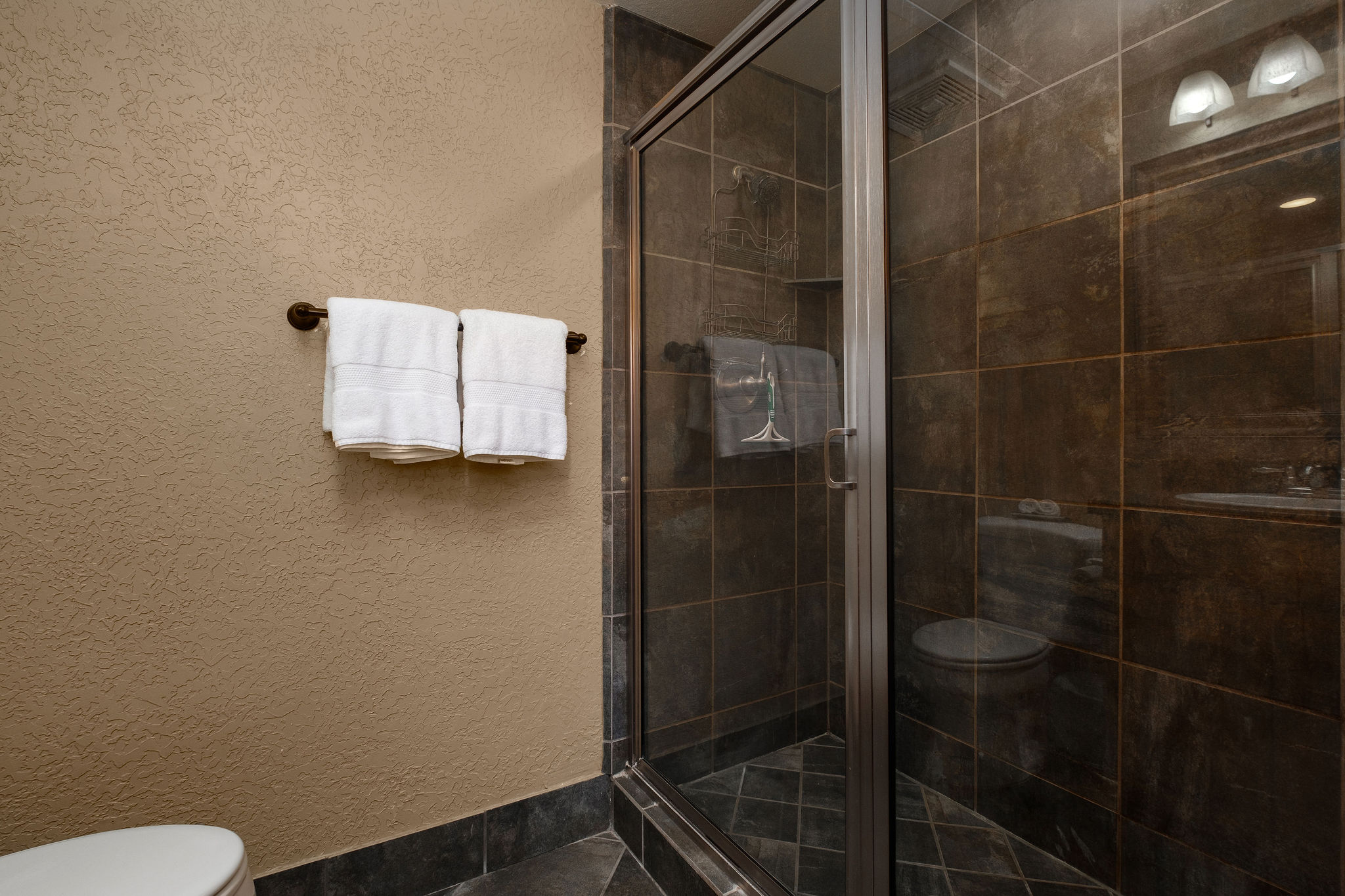 Bathroom featuring toilet and a stall shower