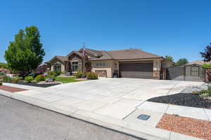 Single story home with a gate, an attached garage, stone siding, stucco siding, and a tile roof