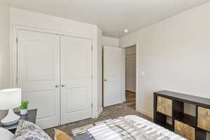 Bedroom with carpet, baseboards, and a closet