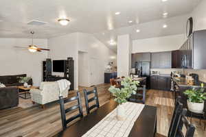 Dining room featuring lofted ceiling, light wood finished floors, ceiling fan, and recessed lighting