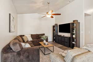 Living area featuring wood finished floors, a ceiling fan, and high vaulted ceiling