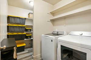 Washroom with washer and dryer and wood finished floors