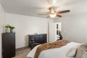 Carpeted bedroom featuring baseboards and ceiling fan