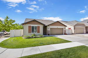Single story home featuring an attached garage, a gate, concrete driveway, and stucco siding