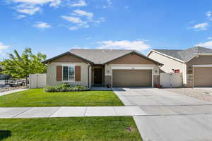 View of front facade featuring a gate, an attached garage, concrete driveway, stucco siding, and stone siding