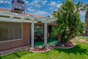 Exterior space featuring a pergola, stucco siding, a patio area, and a yard