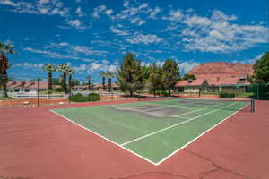 View of tennis court with community basketball court and a mountain view