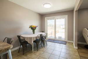 Dining space with baseboards and light tile patterned floors