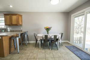 Dining area with baseboards, light tile patterned floors, and recessed lighting