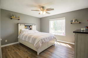 Bedroom with baseboards, wood finished floors, and a ceiling fan
