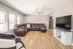 Living area featuring light wood-style floors, ceiling fan, baseboards, and recessed lighting