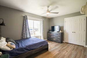Bedroom featuring light wood-style flooring, a ceiling fan, baseboards, and a closet