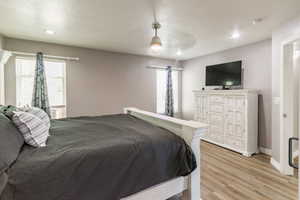 Bedroom featuring light wood-style flooring, ceiling fan, recessed lighting, and baseboards