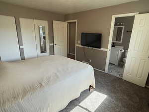 Bedroom with carpet floors, connected bathroom, and baseboards