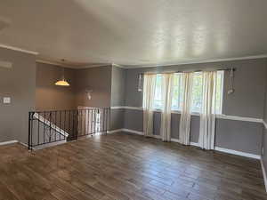 Unfurnished room featuring wood finished floors, baseboards, and ornamental molding