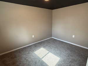 Unfurnished room featuring carpet and baseboards