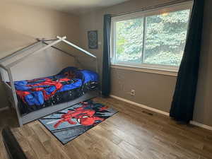 Bedroom with wood finished floors and baseboards