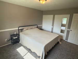 Bedroom featuring carpet flooring, baseboards, and multiple closets