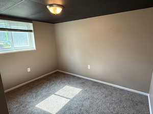 Empty room featuring carpet and baseboards