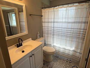 Full bath featuring toilet, vanity, and a shower with shower curtain