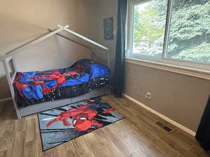 Bedroom with wood finished floors and baseboards