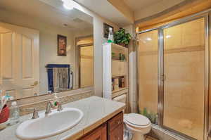 Bathroom with a shower stall, toilet, and vanity