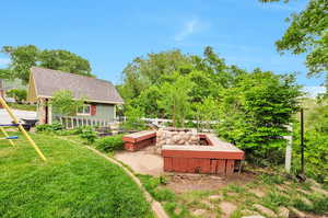 View of green lawn featuring an outdoor structure and a vegetable garden