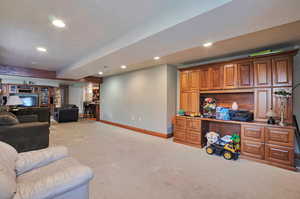 Carpeted living area featuring recessed lighting and baseboards