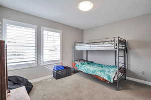 Carpeted bedroom featuring baseboards