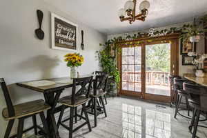 Dining area with a chandelier and a textured ceiling