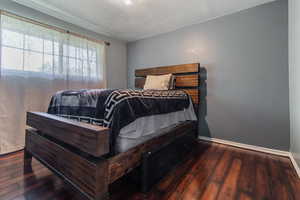 Bedroom with hardwood / wood-style floors and baseboards