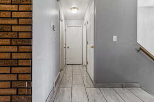 Hallway featuring baseboards and a textured ceiling
