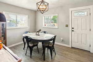 Dining area featuring a chandelier, wood finished floors, and baseboards