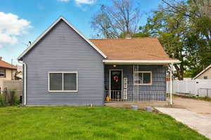 View of front of house with covered porch, roof with shingles, and a chimney