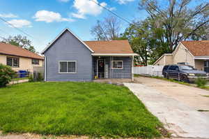 View of front of house with driveway, a porch, and a shingled roof