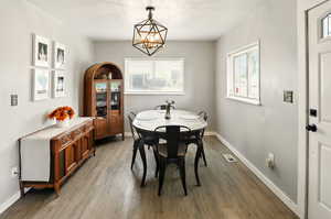 Dining space with a chandelier, light wood finished floors, plenty of natural light, and baseboards
