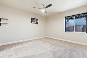 Empty room with ceiling fan, carpet floors, and baseboards