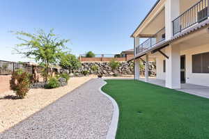 Fenced backyard featuring a balcony and a patio area