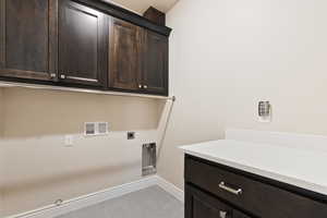 Laundry area featuring hookup for a washing machine, hookup for an electric dryer, cabinet space, baseboards, and hookup for a gas dryer
