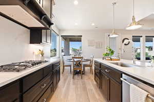 Kitchen with appliances with stainless steel finishes, a sink, plenty of natural light, under cabinet range hood, and recessed lighting