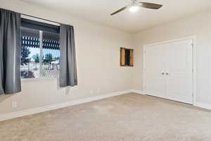 Unfurnished bedroom featuring carpet, baseboards, a ceiling fan, and a closet