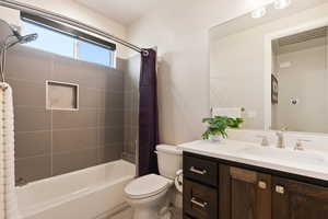 Full bathroom with shower / bath combination with curtain, vanity, and toilet