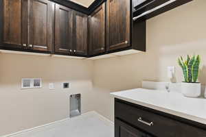 Laundry area with washer hookup, electric dryer hookup, cabinet space, and baseboards