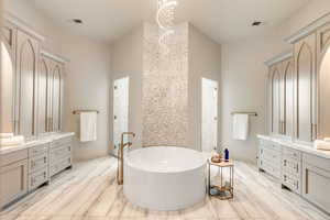 Full bathroom with vanity and a soaking tub