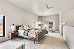 Carpeted bedroom featuring attic access and baseboards