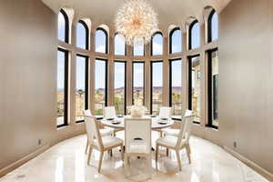 Dining room with a chandelier, a mountain view, and a towering ceiling