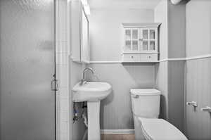 Full bathroom featuring toilet, a shower stall, and tile patterned floors