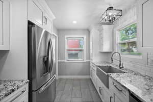 Kitchen featuring appliances with stainless steel finishes, a sink, white cabinetry, healthy amount of natural light, and recessed lighting
