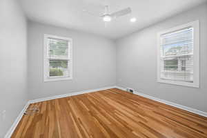 Spare room featuring light wood-type flooring, baseboards, and a ceiling fan