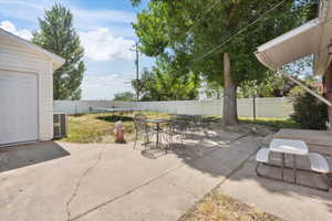 Fenced backyard with a trampoline, a patio area, and outdoor dining space